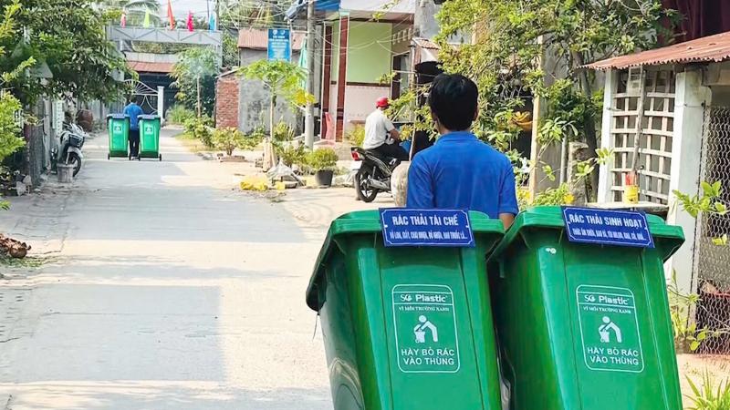 Hình ảnh minh họa một nhóm người Việt Nam đang tham gia hoạt động bảo vệ môi trường như trồng cây hoặc dọn rác, thể hiện tinh thần cộng đồng và hành động thiết thực